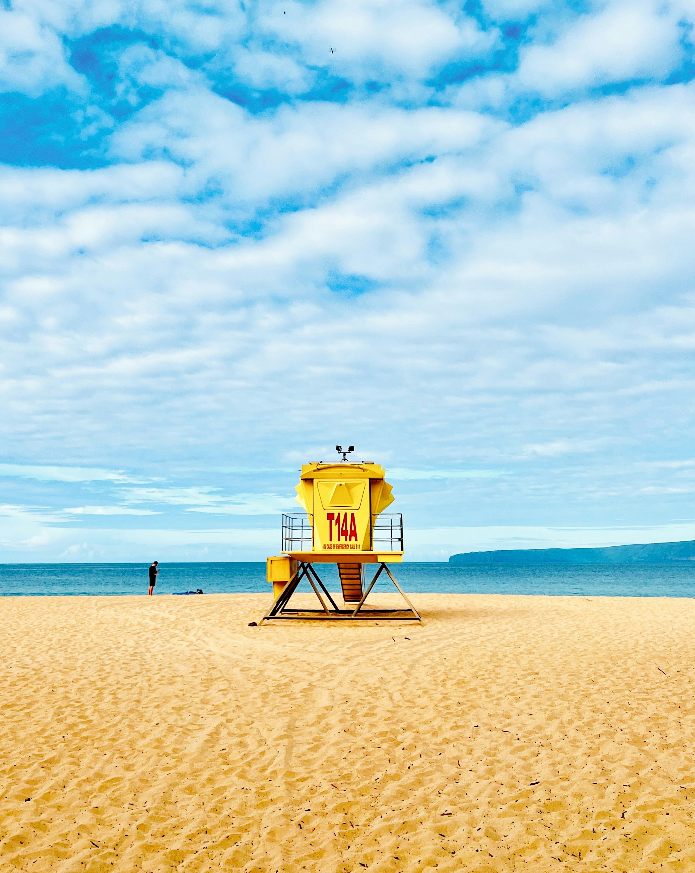 a lifeguard tower on a beach with a sky background