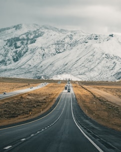 Long highway with a moving van carrying belongings across countryside.