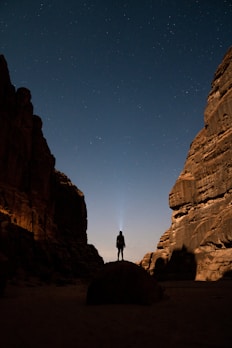 a person standing in the middle of a desert at night