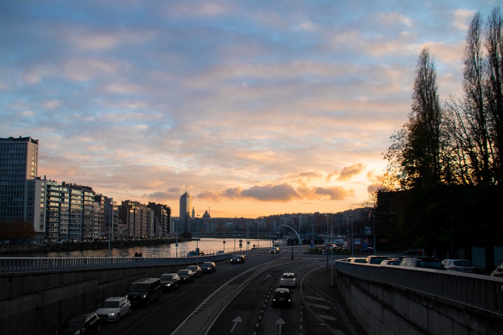 a city street filled with lots of traffic under a cloudy sky