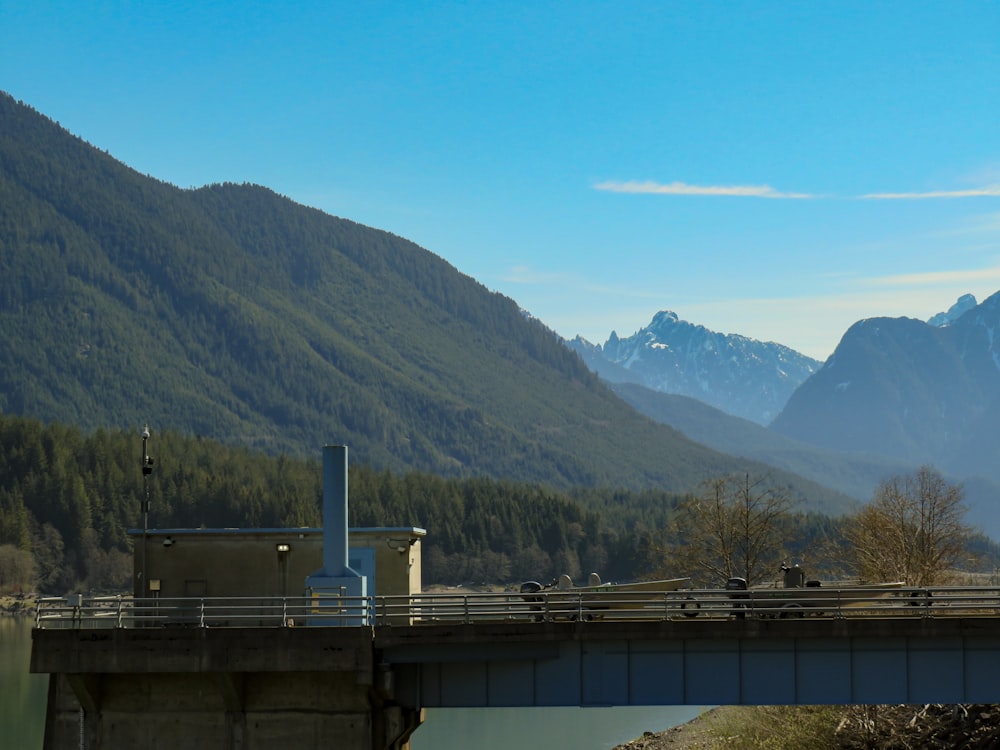 a bridge over a body of water with mountains in the background