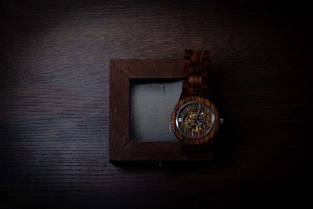 Eine Uhr in einer Holzkiste auf einem Tisch