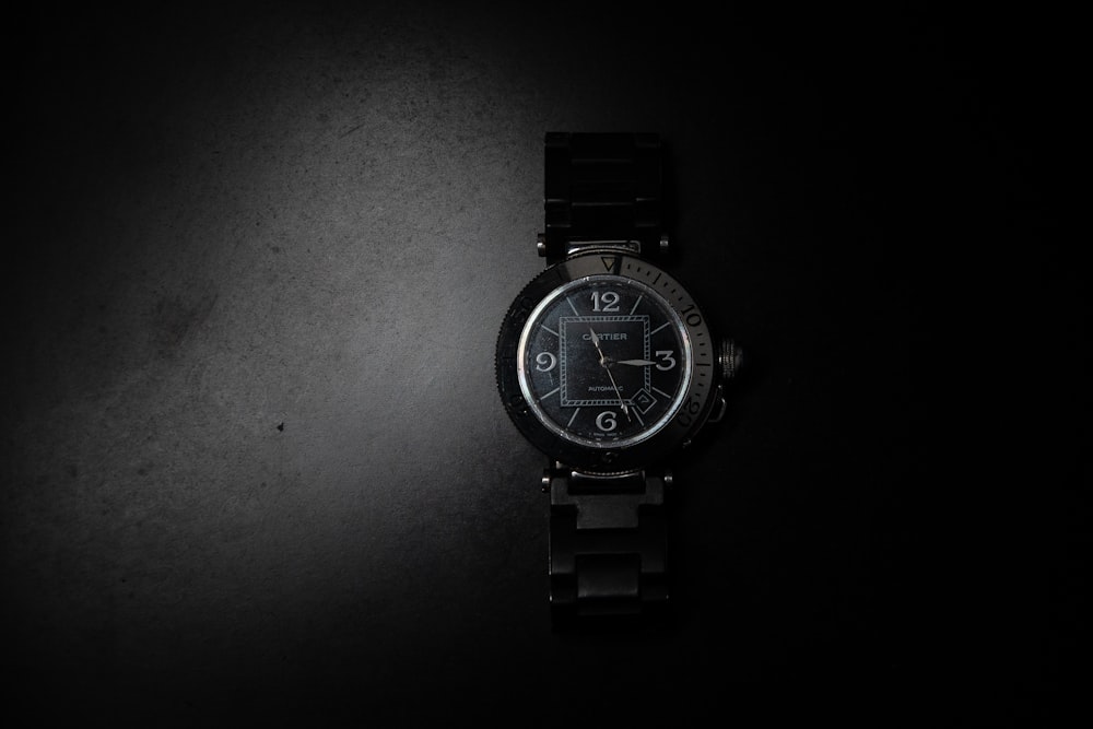 a watch sitting on top of a black table