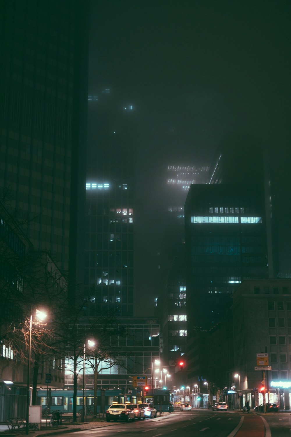 a city street at night with tall buildings