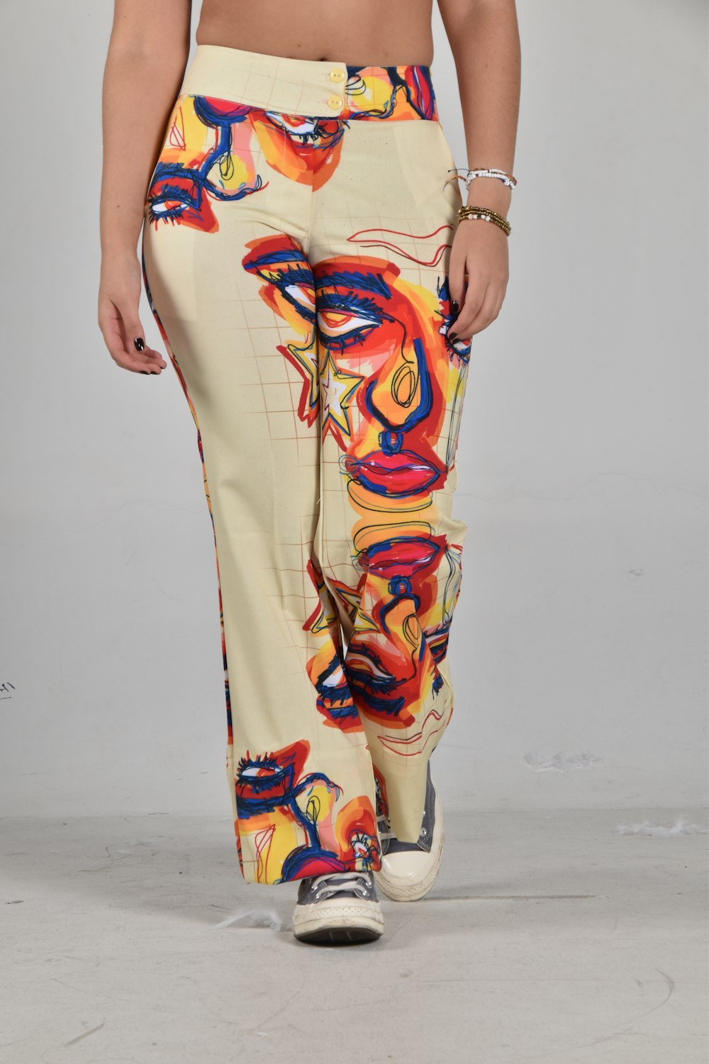a woman is walking down a runway wearing colorful pants