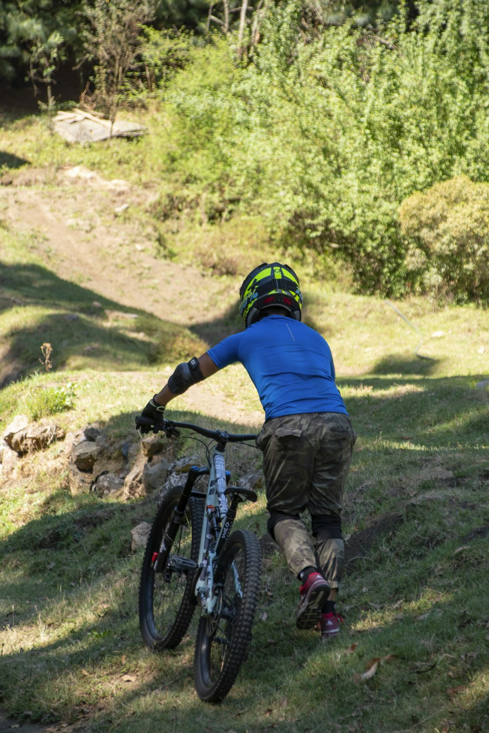 a person riding a bike on a grassy hill