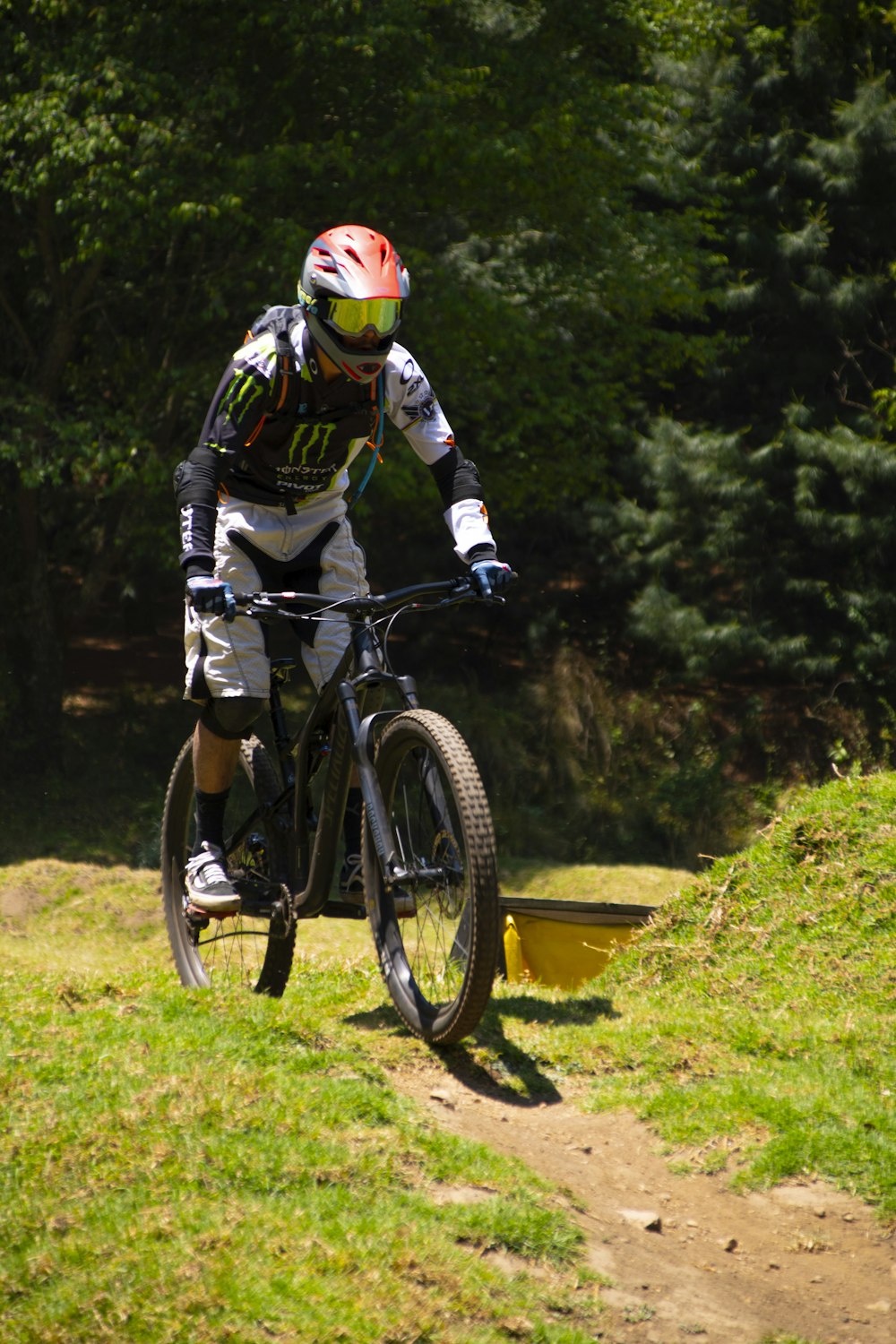 a man riding a bike down a dirt road