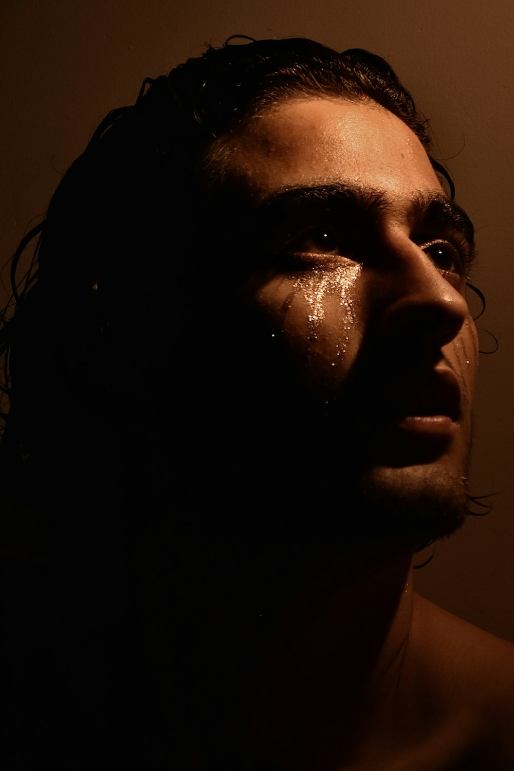 a man with a wet face in the dark
