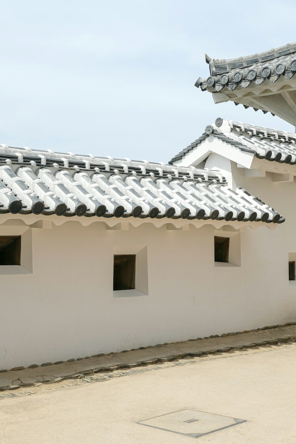 a white building with two windows and a roof