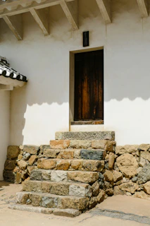 Finished stone steps leading up to a rustic entrance.
