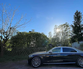A comfortable sedan parked outside Hudson airport at sunrise.