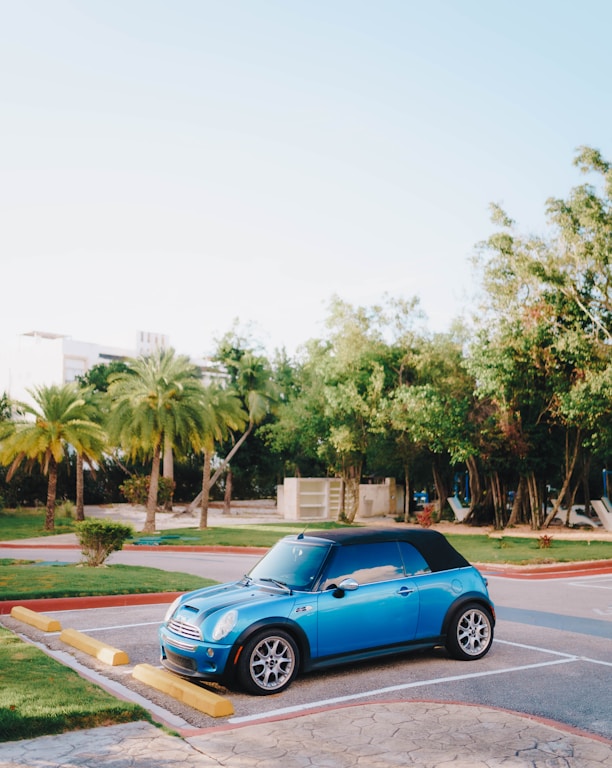 a small blue car parked in a parking lot