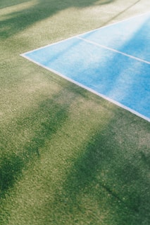 Wide shot of a newly installed tennis court with smooth epoxy resin surface and vibrant colors.