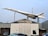 A Concorde jet in Air France livery is displayed on a rooftop at an automobile business named Concorde. The aircraft is mounted as if taking off, showcased on a tall stand. Multiple cars are parked in front of the building.