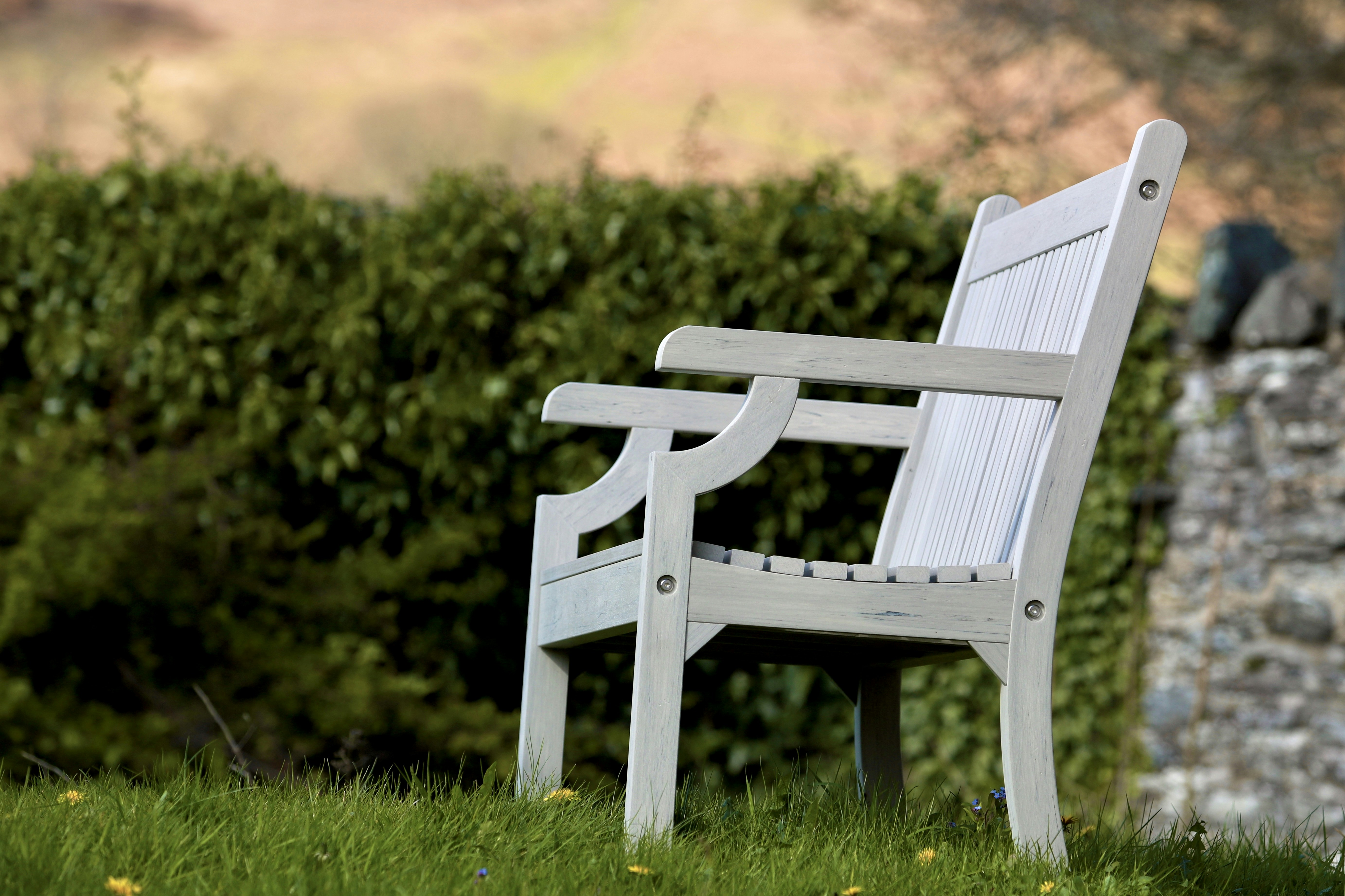 a white wooden bench sitting in the grass