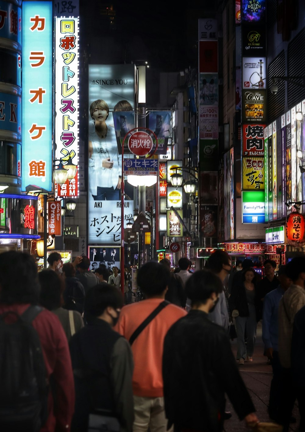 a group of people walking down a street at night