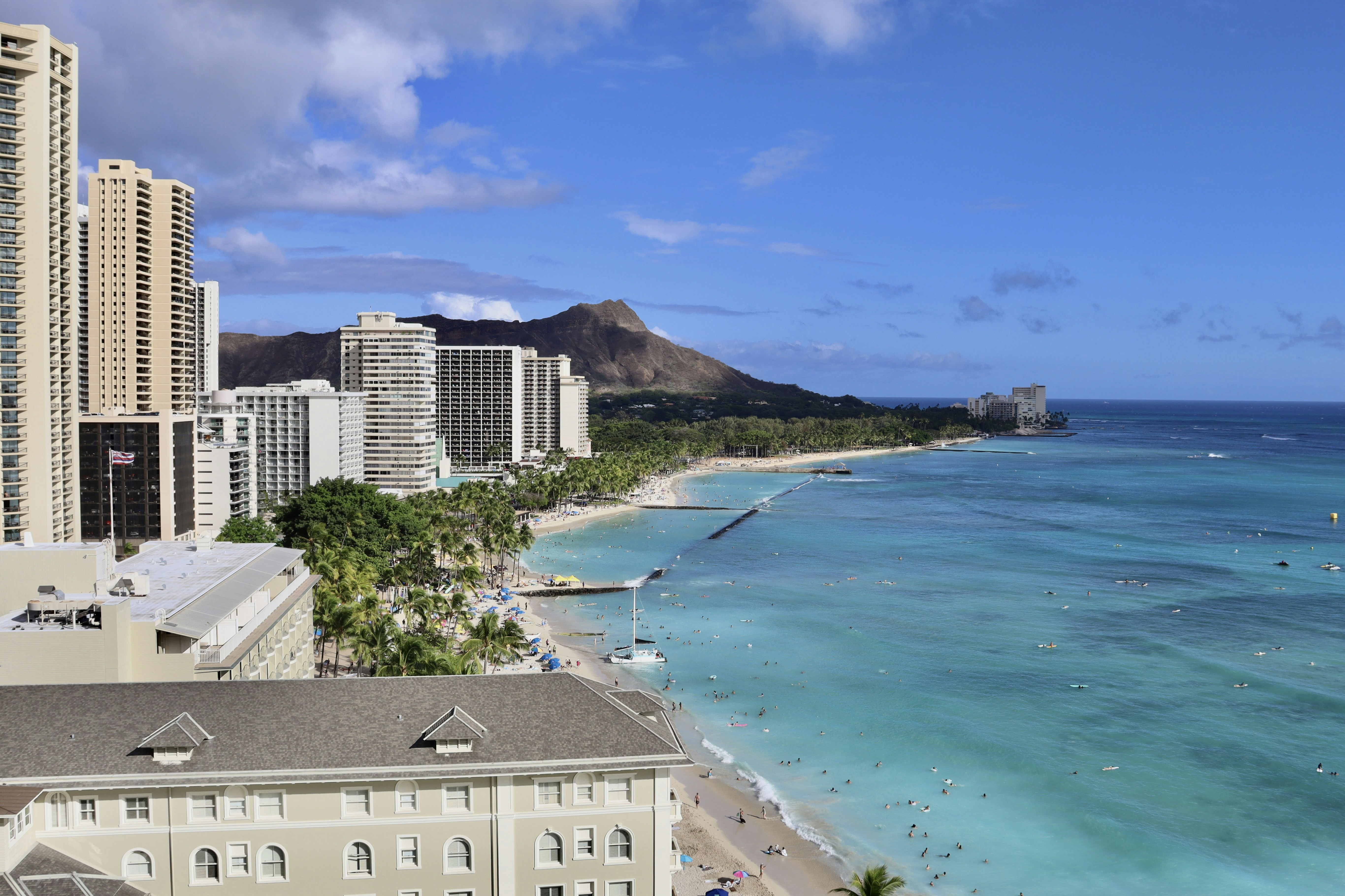 View of Waikiki Beach and palm trees from a high-rise vacation rental balcony on Oahu