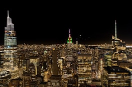 A vibrant global city skyline illuminated at night, reflecting strength and leadership through deep red lighting.