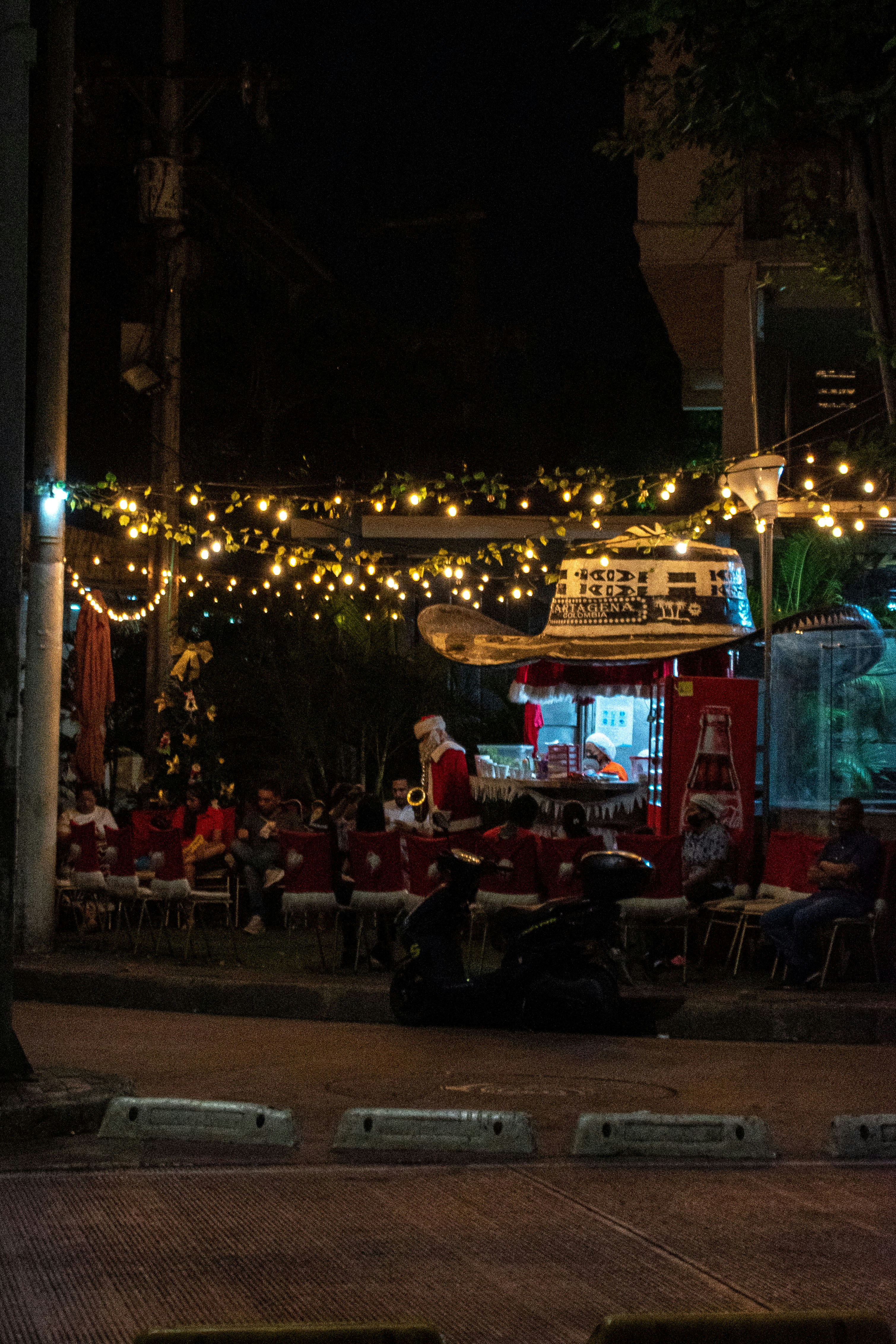 a group of people sitting at tables under lights