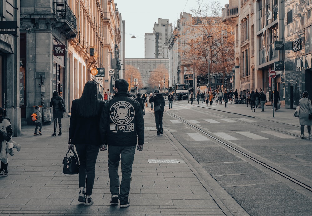 um casal de pessoas andando por uma rua
