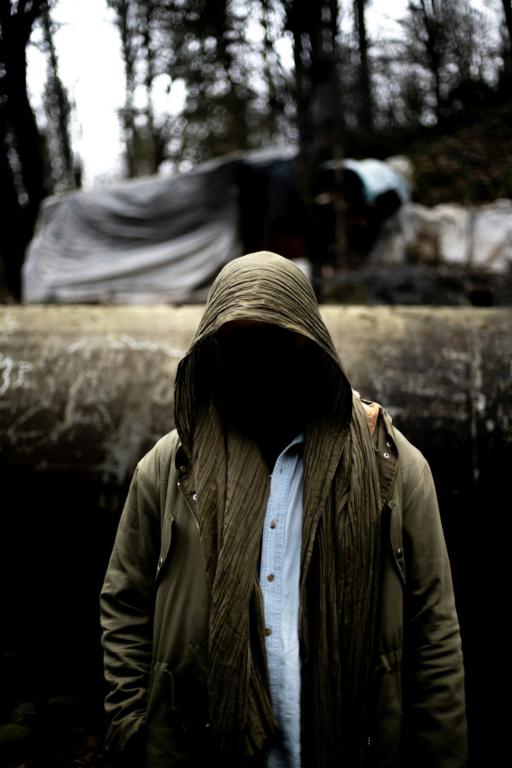 a man in a hooded jacket standing in the woods
