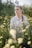 a woman standing in a field of flowers