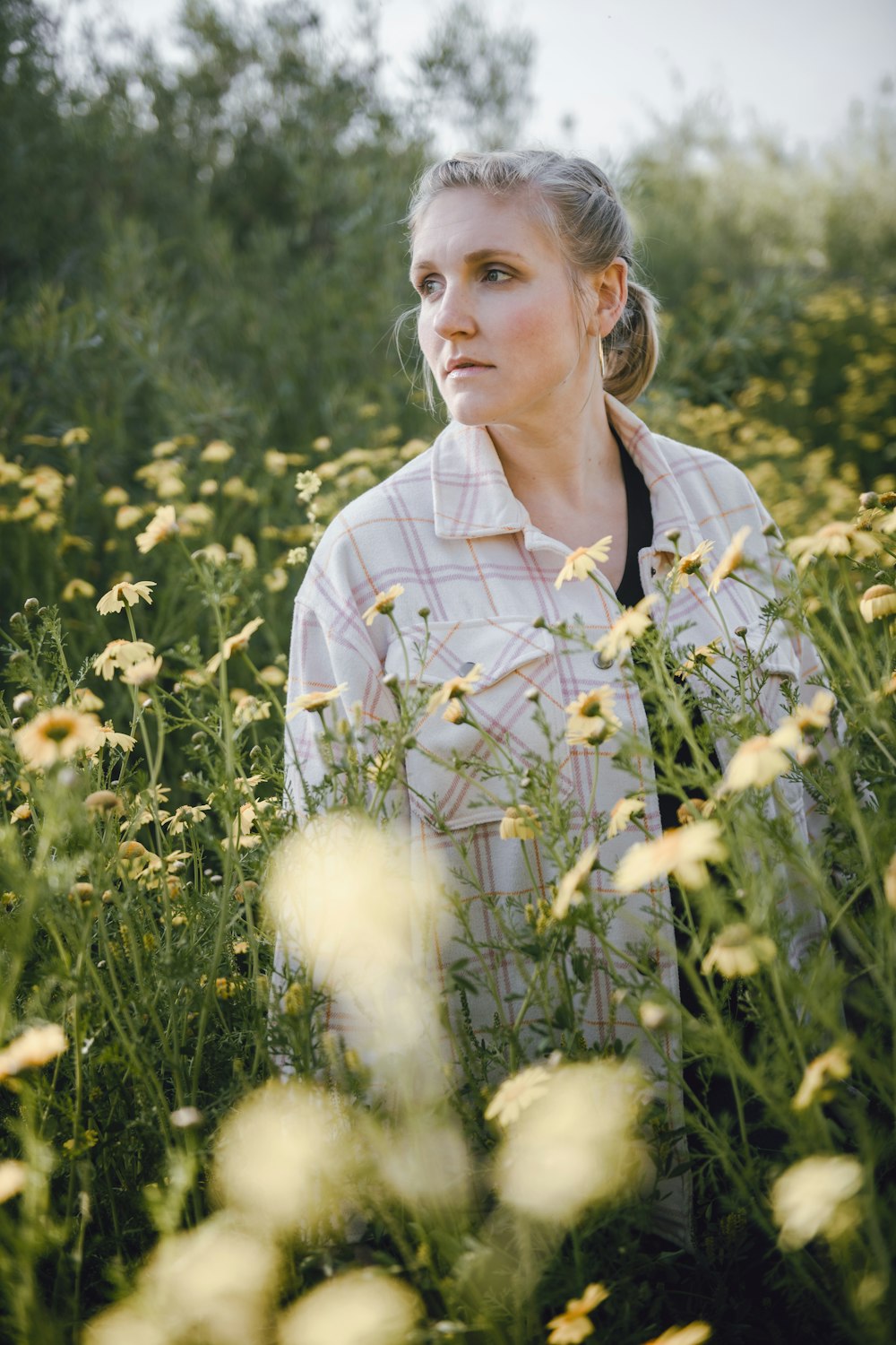 uma mulher em pé em um campo de flores