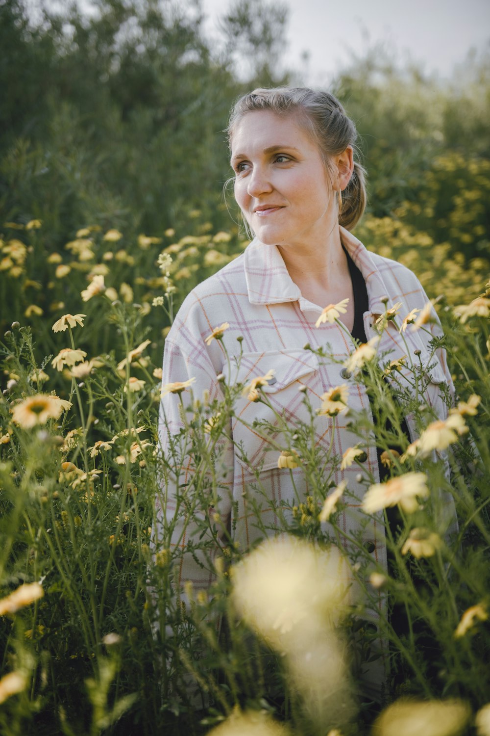 a woman standing in a field of flowers