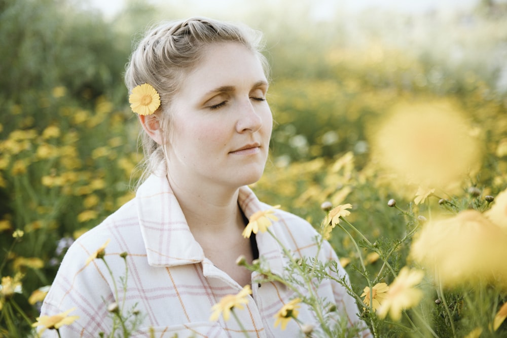 uma mulher em pé em um campo de flores amarelas