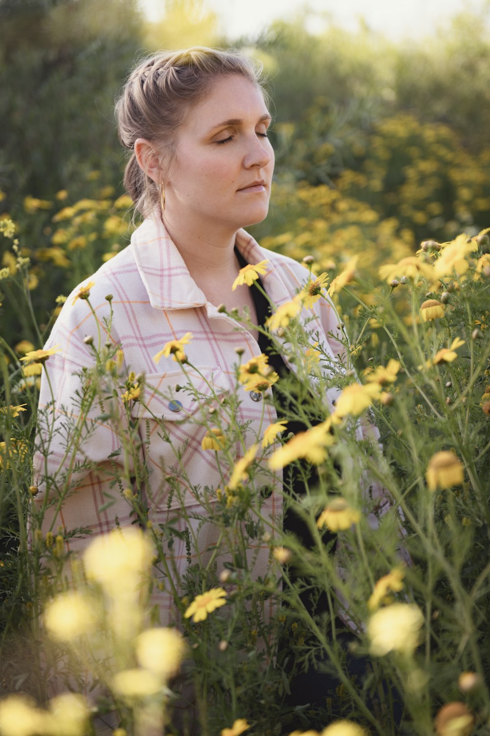 a woman standing in a field of yellow flowers