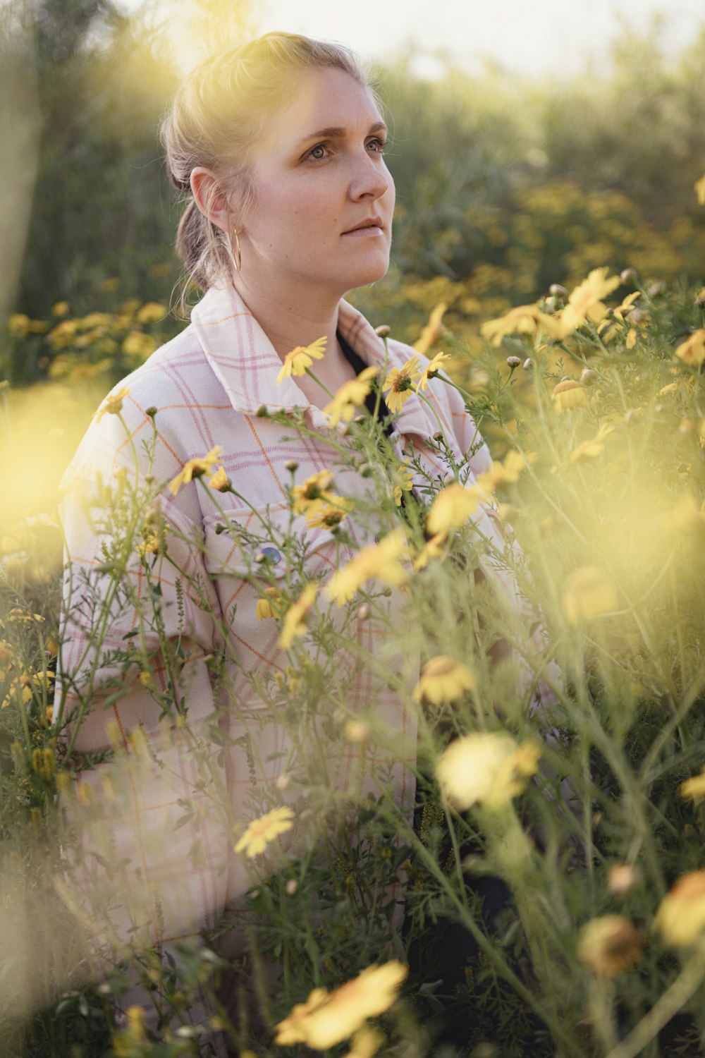 a woman standing in a field of yellow flowers