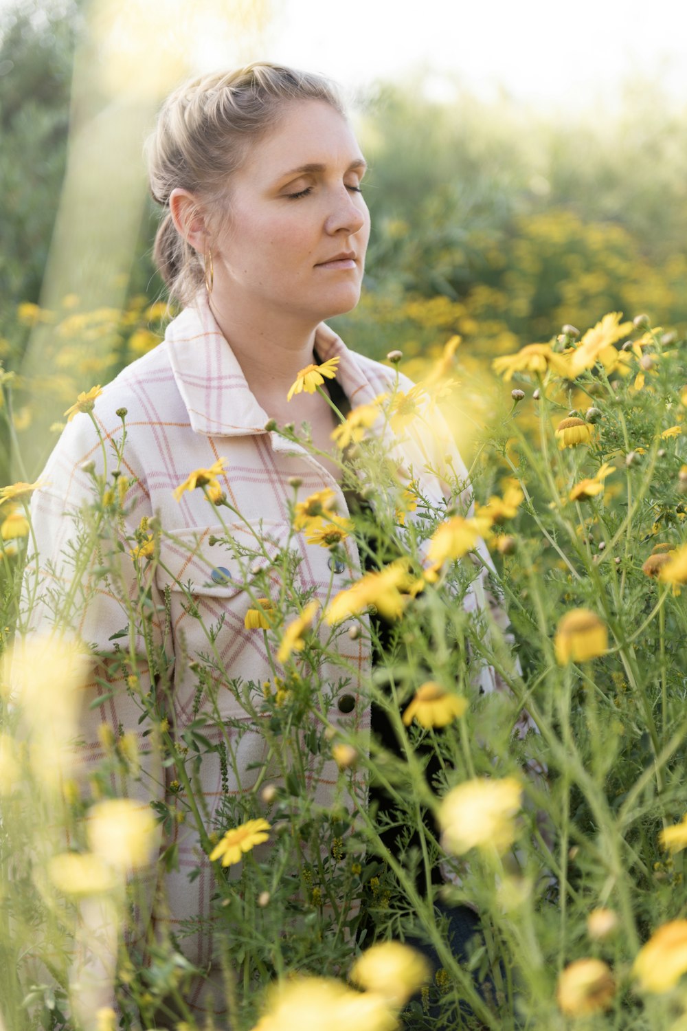 a woman standing in a field of yellow flowers