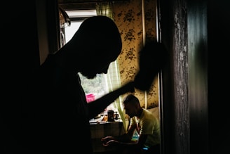 a man standing in a kitchen next to a window