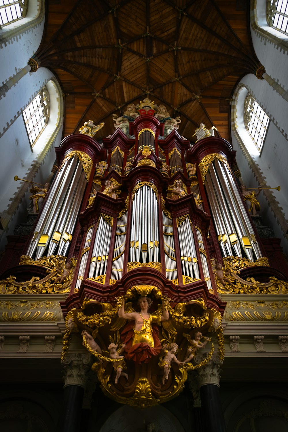 a large pipe organ in a church with a statue of a woman