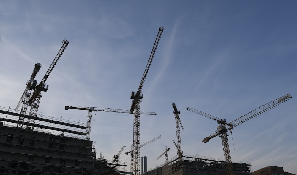 a group of cranes that are next to a building