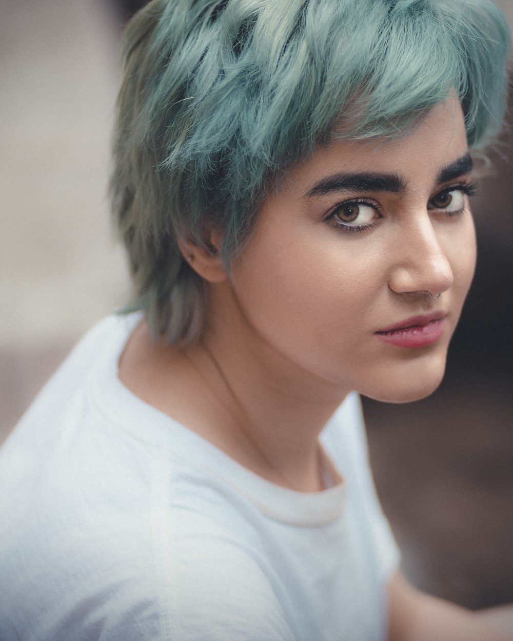 Una mujer con cabello verde y una camisa blanca