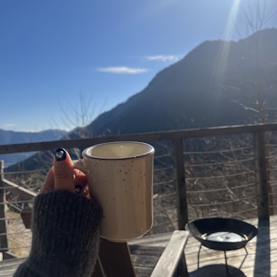 Close-up of a hand-painted ceramic mug with the Piccolo Ranch di Montagna logo