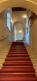 Wide shot of a grand staircase with polished marble steps gleaming under soft lighting.