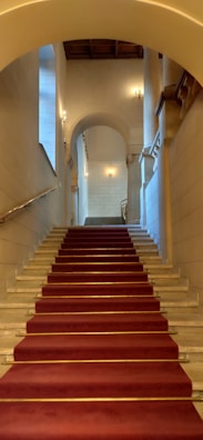Wide shot of a grand staircase with polished marble steps gleaming under soft lighting.