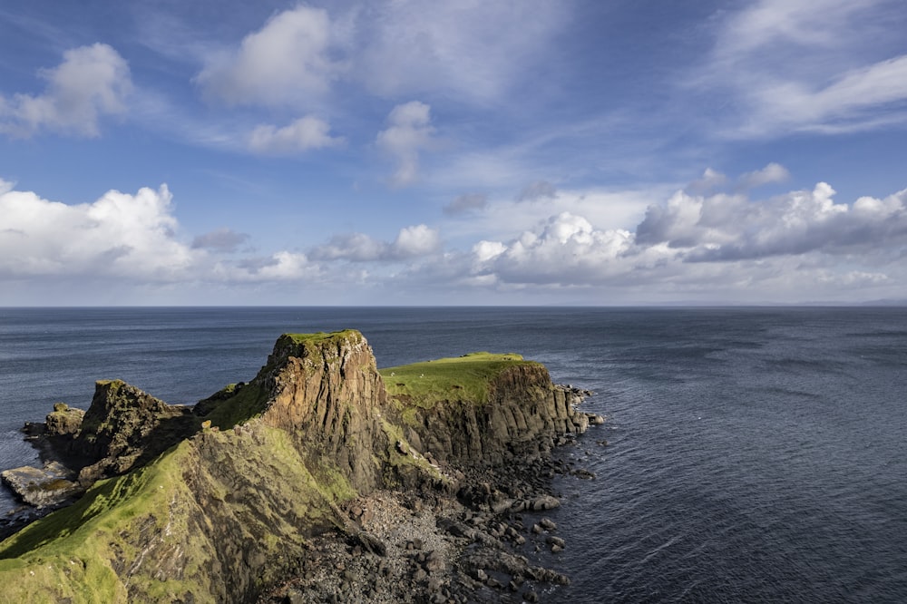 a large body of water sitting next to a lush green hillside