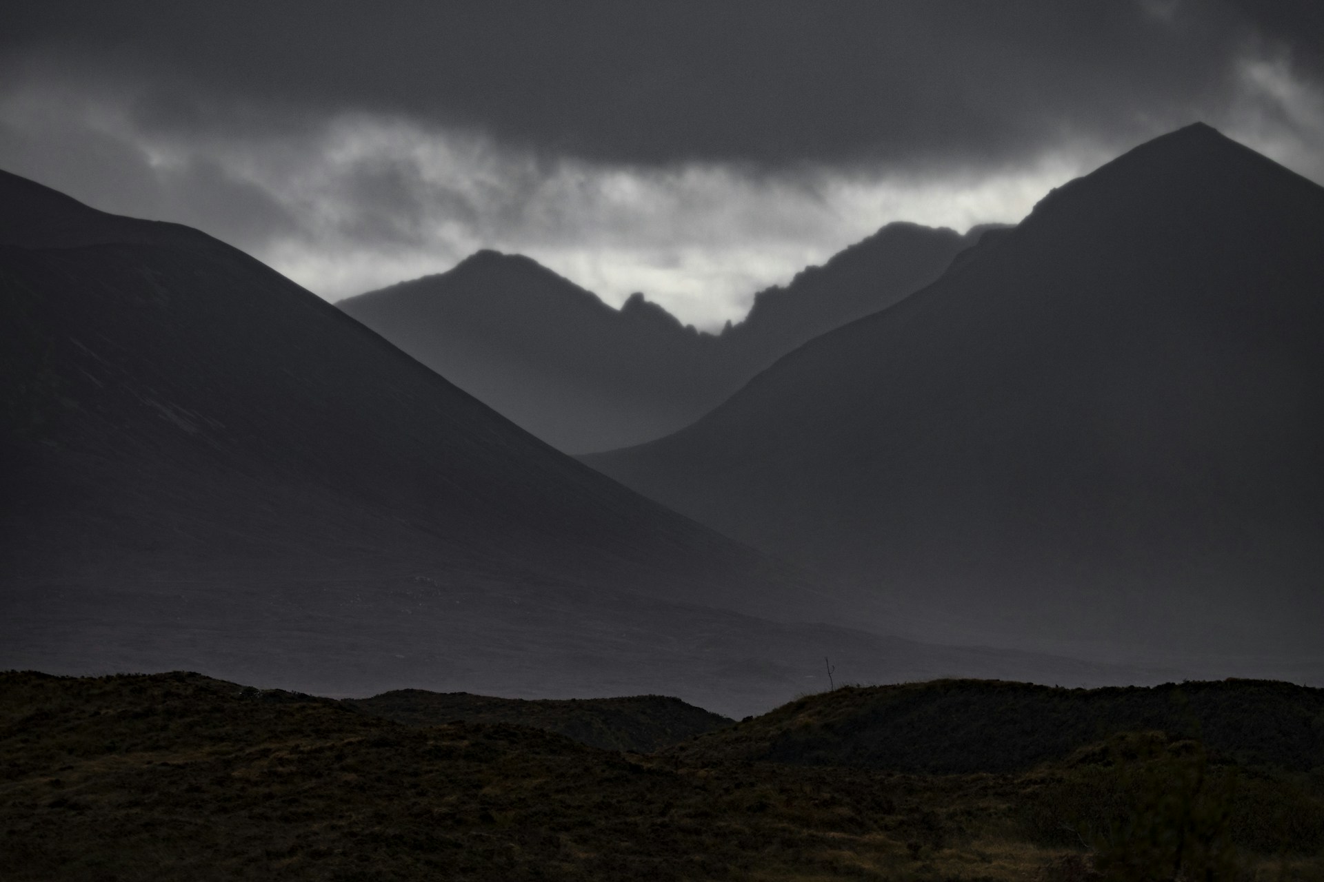 A cinematic landscape with moody skies and layered mountains, rendered in rich tones that blend seamlessly into the dark theme.