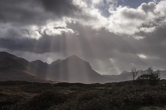 the sun is shining through the clouds over the mountains