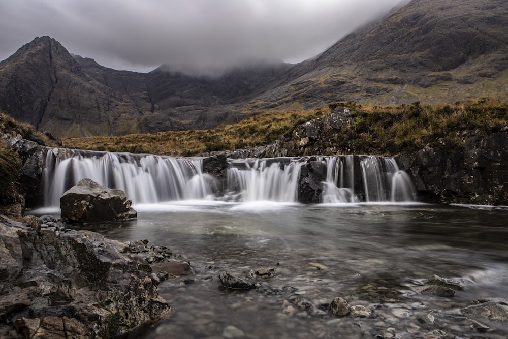 a small waterfall in the middle of a mountain