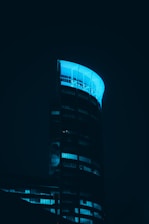 a very tall building lit up in the dark