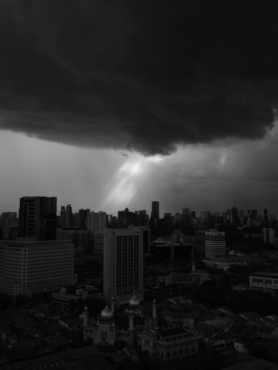 Singapore skyline silhouetted under a dramatic April thunderstorm, the city's signature inter-monsoon weather pattern