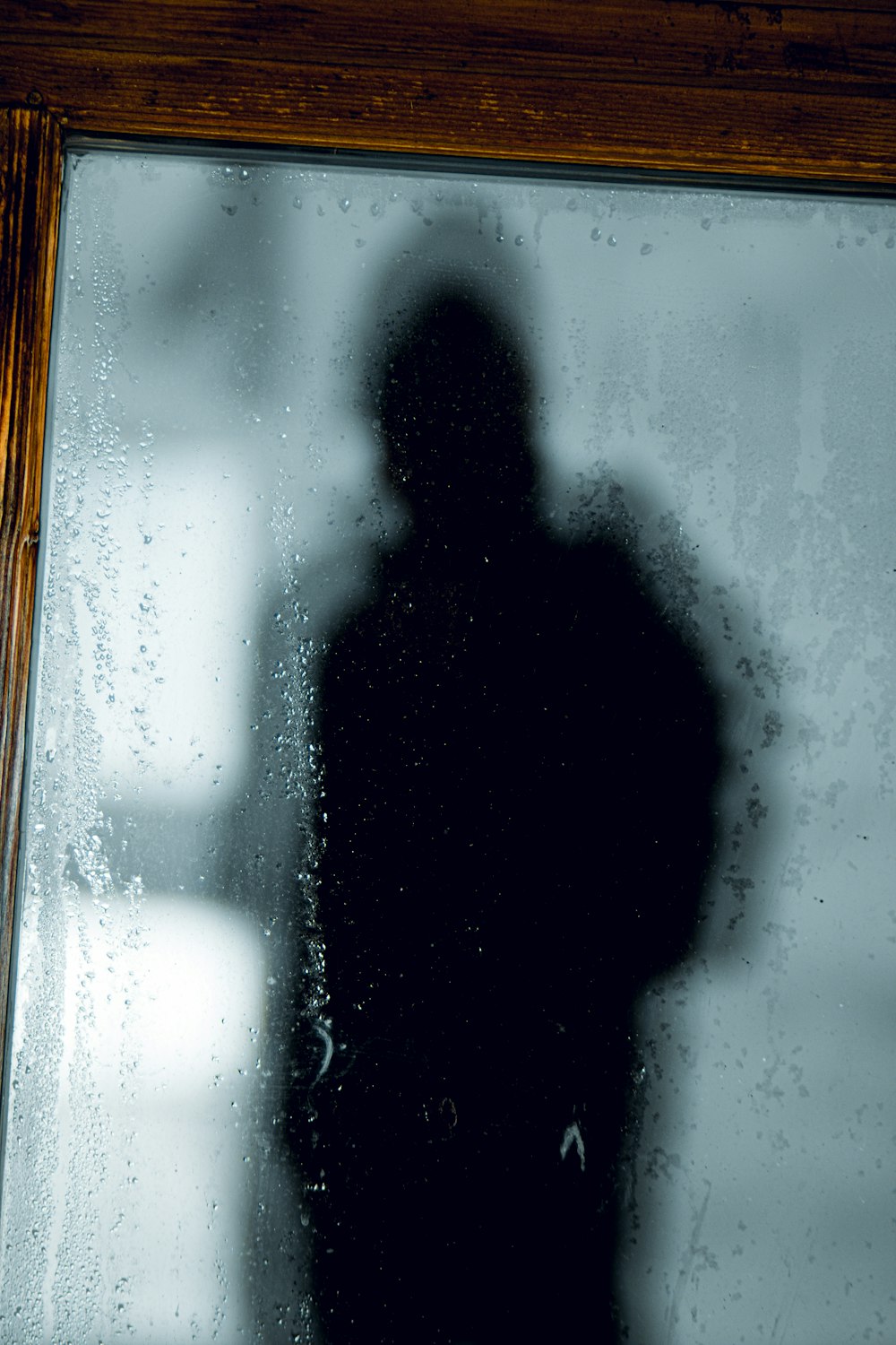 a shadow of a person standing in front of a window