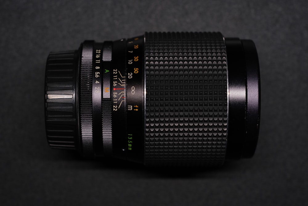 um close up de uma lente de câmera em uma superfície preta