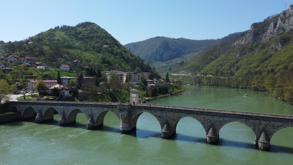 a bridge over a river with mountains in the background