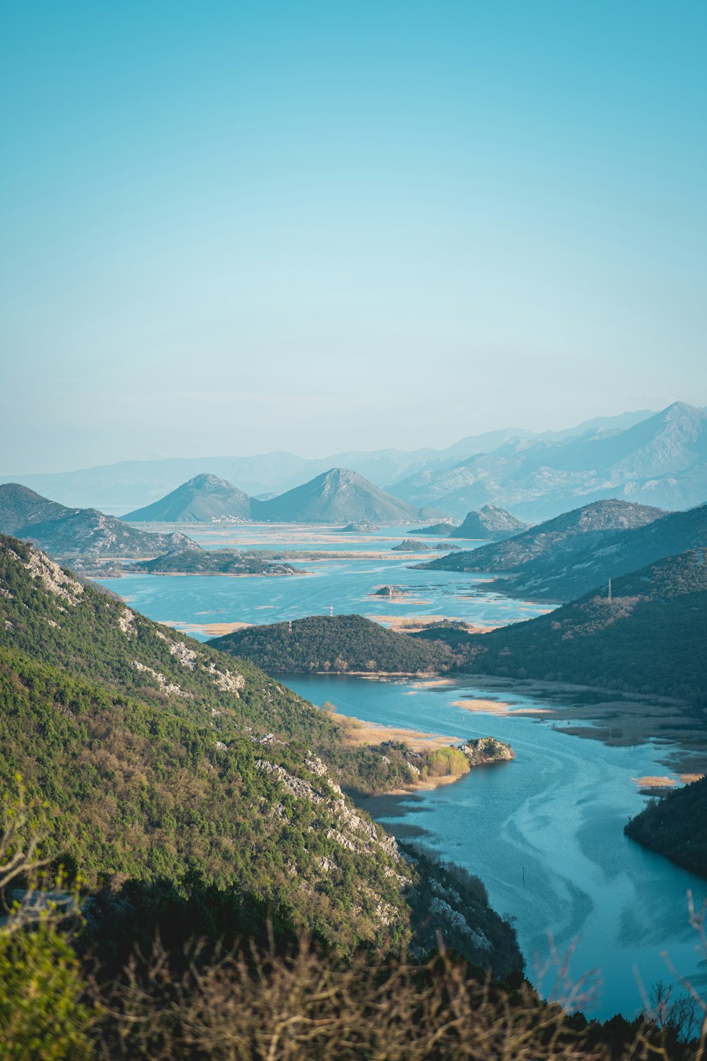 a view of a lake and mountains from a hill