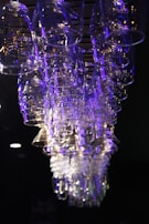 A set of LED cups and glasses glowing vibrantly in a dark setting.